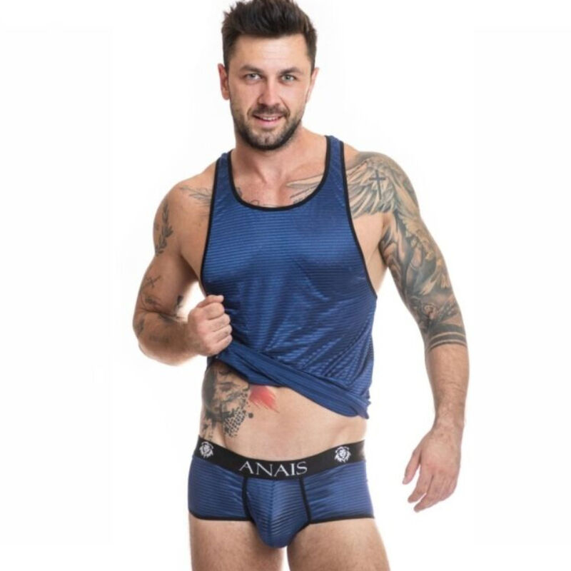 Fitness model wearing blue mesh tank top and matching briefs, lifting the shirt to reveal the Anais waistband and tattoos on arms and torso.