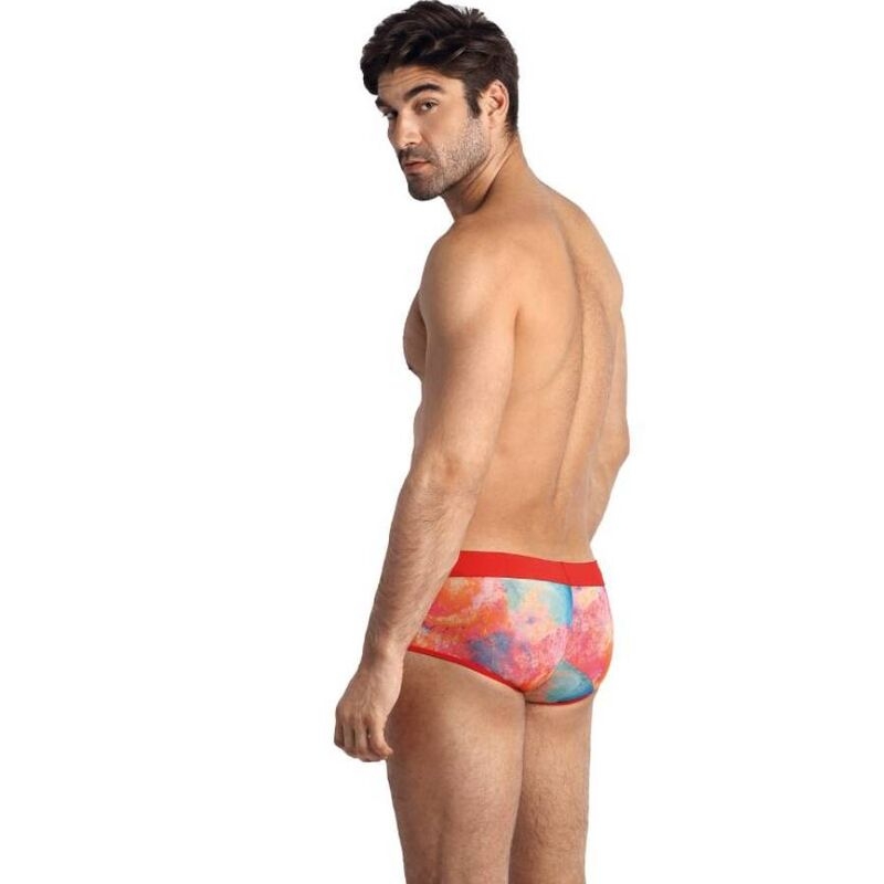Male model wearing red-trimmed, colorful tie-dye swim briefs, viewed from the side/back for product showcasing