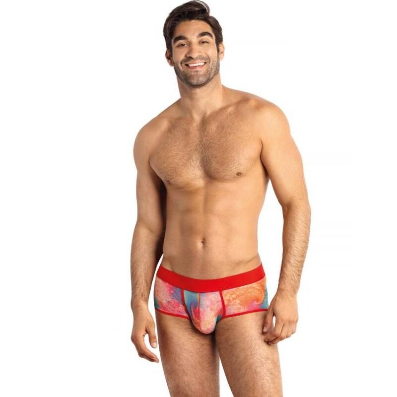 Smiling man standing in colorful patterned briefs with a red waistband.