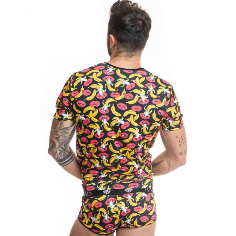 Man facing away wearing a black T-shirt and matching print underwear with yellow bananas and red lips; tattoos visible on arms.