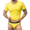 Man in a bright yellow athletic shirt and matching yellow briefs with a black waistband reading ANAIS, flexing his torso and showing tattoos on his arms.