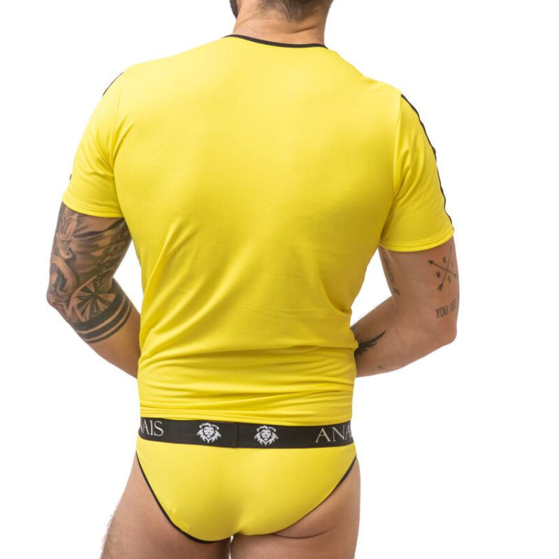 Back view of a man in a bright yellow fitted T-shirt and matching yellow briefs with a black waistband featuring a logo, tattoos visible on arms.