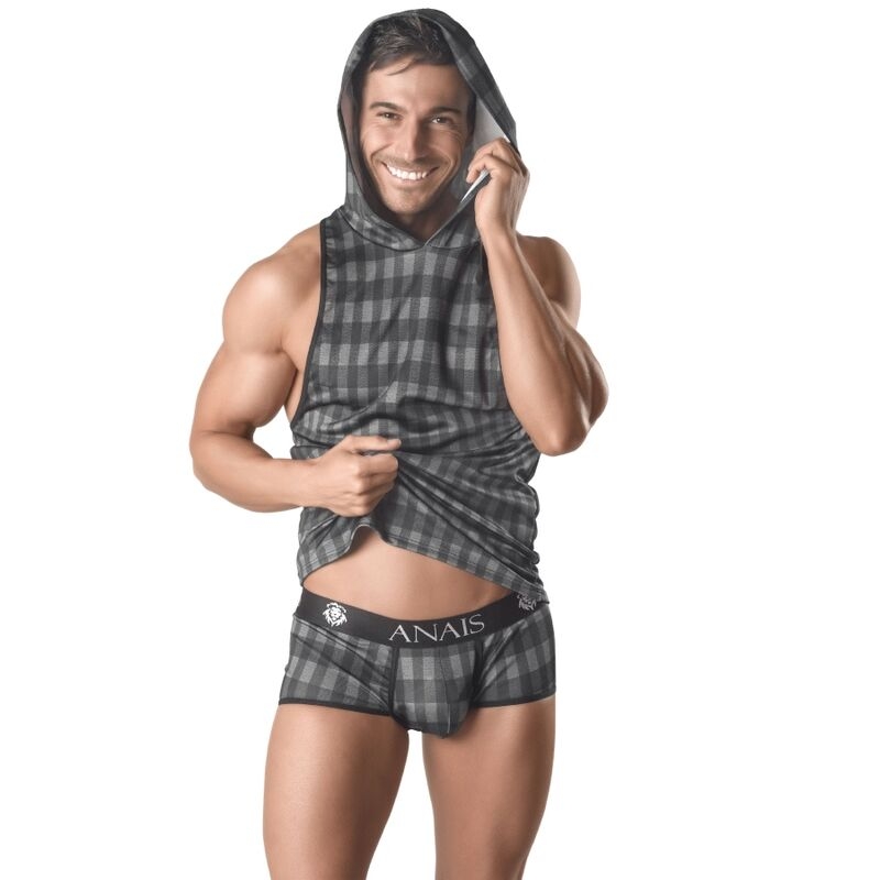 Muscular man in gray plaid hoodie and boxer briefs, smiling while talking on a cell phone.