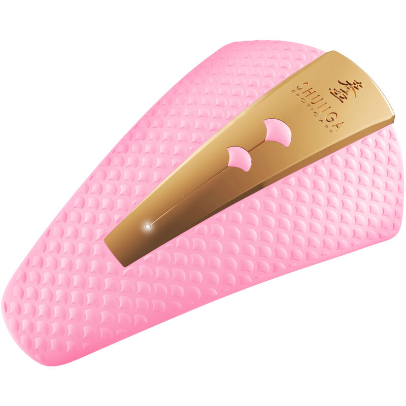 Gold-toned hair clip with pink accents resting on a pink textured surface.
