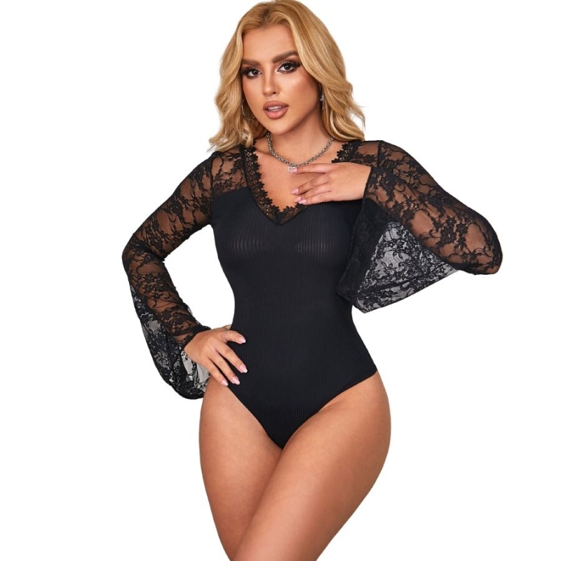 Woman modeling a black lace-sleeve bodysuit with a sheer lace yoke and bell sleeves, posing confidently.