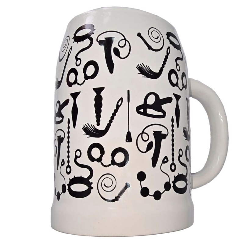 White ceramic mug viewed from the side, covered in bold black abstract doodle shapes around the surface.