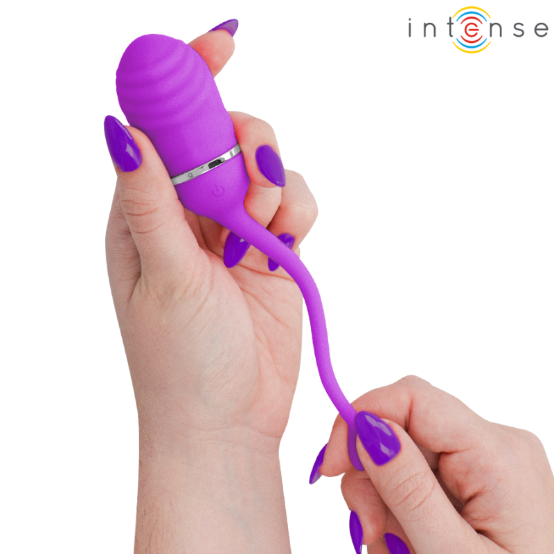 img_223829_58d9ddf8734cf14789db8ef4094bd40f_1png - Sex Shop | Lodia.gr - 100% Διακριτική Και Παράδοση με courier της επιλογή σας Close-up of a hand holding a purple silicone vibrator with a curved shaft and flared base, showing how it’s used; Intense logo in the top-right corner.