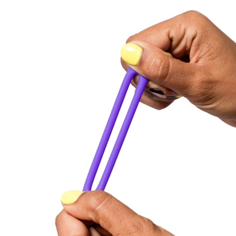 Hands stretch a purple double-banded fidget toy between fingers for stress relief or sensory play.