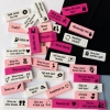 Assorted white and pink blocks with flirtatious messages scattered on a surface (e.g., 'Tell me what you want', 'Massage me').
