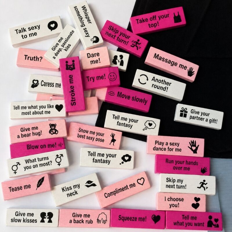 Assorted white and pink blocks with flirtatious messages scattered on a surface (e.g., 'Tell me what you want', 'Massage me').
