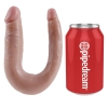 Flesh-colored U-shaped sex toy beside a red can labeled Pipedream.